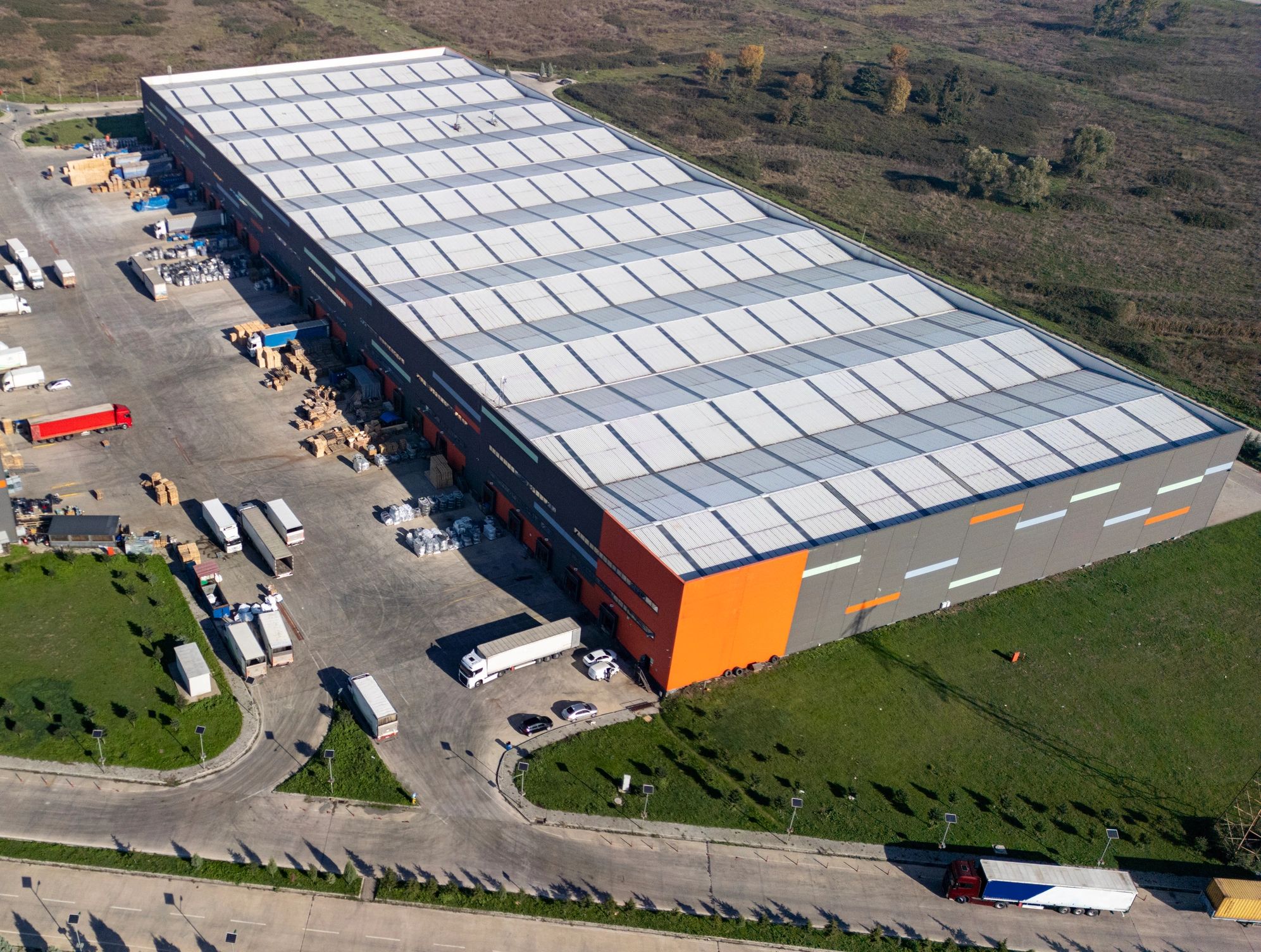 Aerial view of logistics center with trucks and warehouse operations